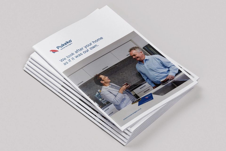 A stack of Pukeko Rental Managers brochures on a pale surface.